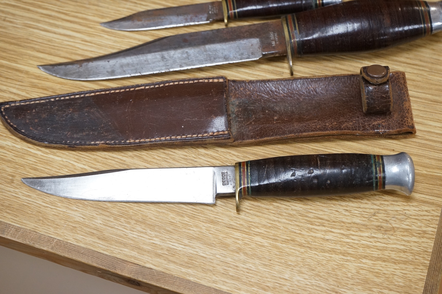 A 1907 bayonet by Wilkinson in its steel mounted leather scabbard, another similar with leather frog, two small British bayonets, a Continental bayonet, and two assorted hunting knives (7)